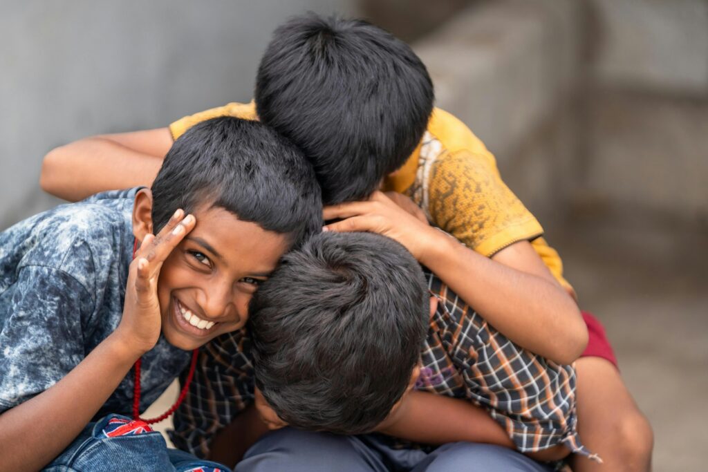 Three boys sharing a hug and smiles