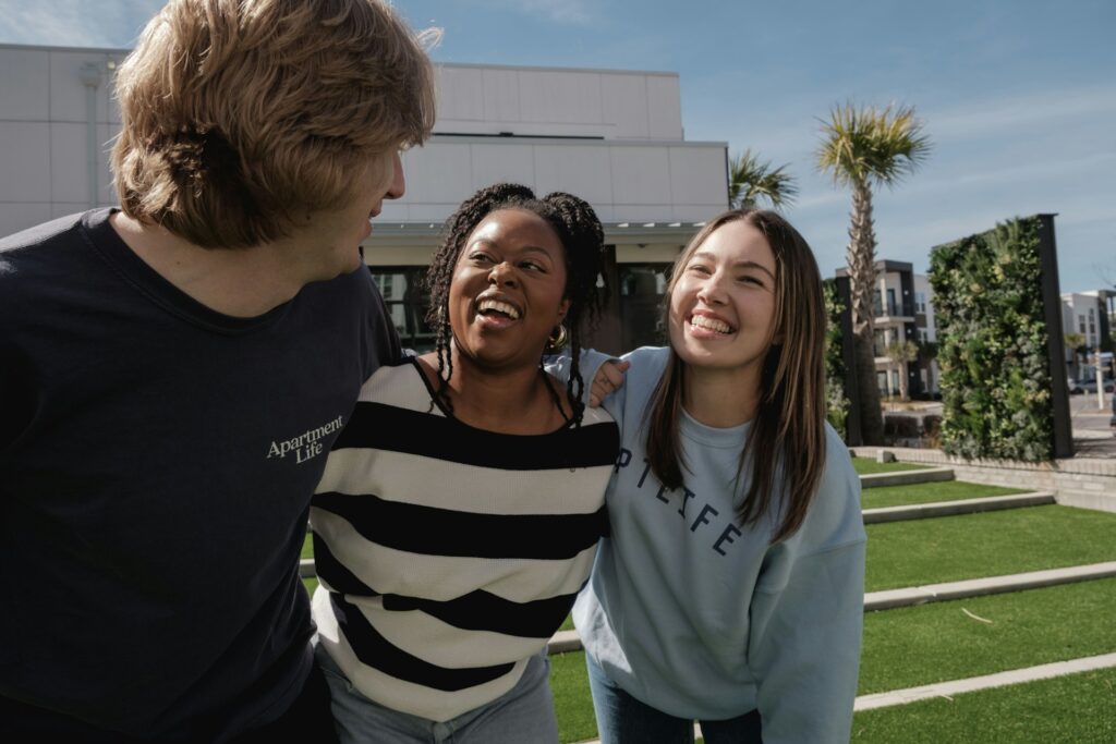 Three friends laughing together on a sunny day