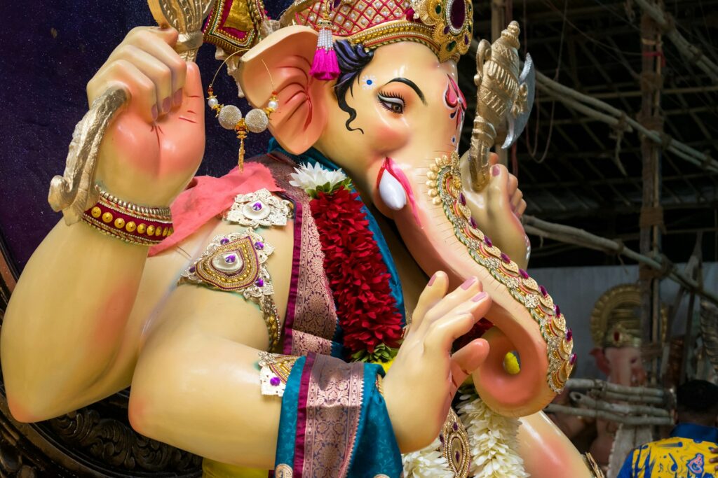Decorated Ganesha idol with ornate jewellery and a floral garland