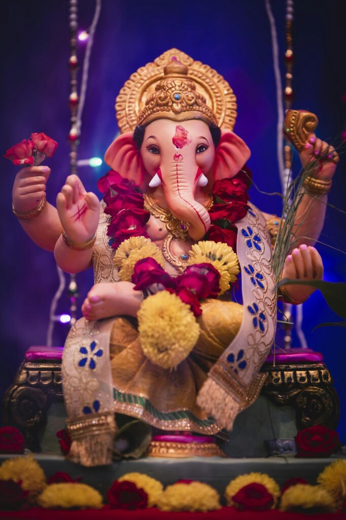 Ganesha idol adorned with red roses and yellow marigolds