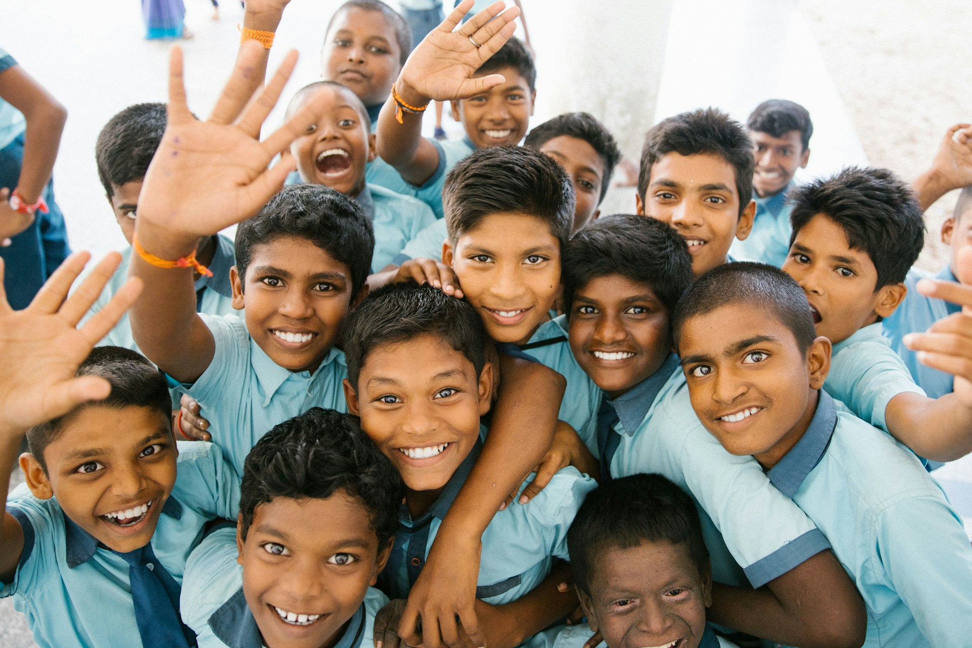 Smiling Indian schoolchildren waving at the camera