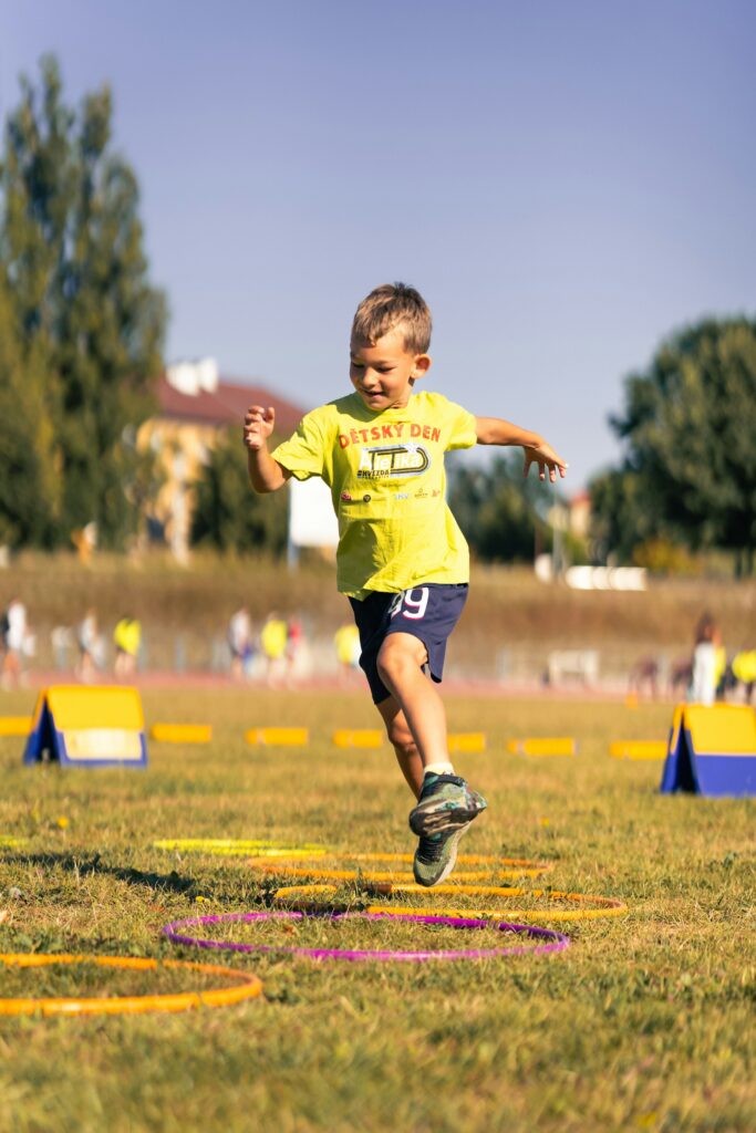 A boy jumping through hoops in an outdoor activity