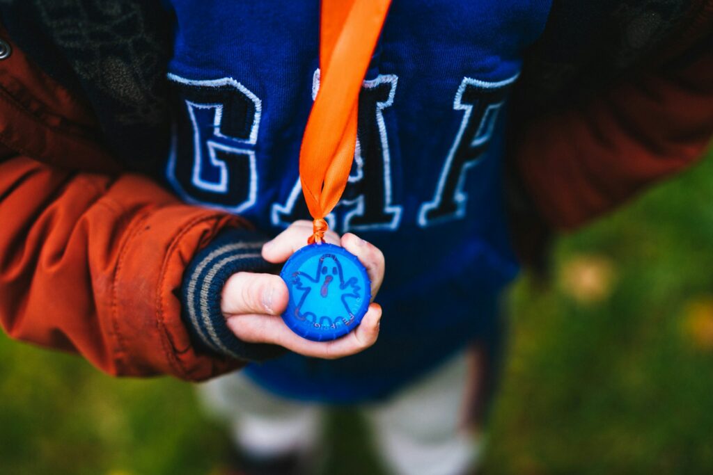 A young boy holding his medal